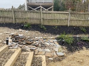 A backyard with a fire pit and steps leading up to it showcased in the project gallery.