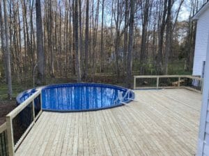 The project features a wooden deck surrounding an inground pool.