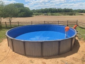 Project: A swimming pool with a blue tarp on it.
