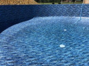Project: A blue tiled swimming pool with a blue liner is showcased in the gallery.