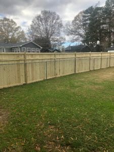Gallery: A beautiful project showcasing a wooden fence seamlessly integrated with a chain link fence in a vibrant backyard.