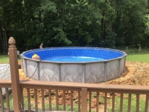 A project involving the installation of a swimming pool in a backyard with a deck.