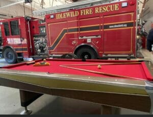 A pool table in front of a fire truck.
