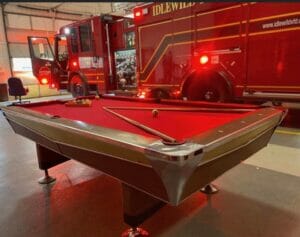 A billiards table in front of a fire truck.