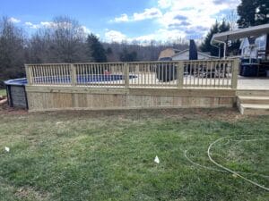 Project: A backyard with a wooden deck and a pool.