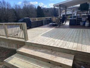 Project Gallery: A wooden deck with steps leading to a patio.